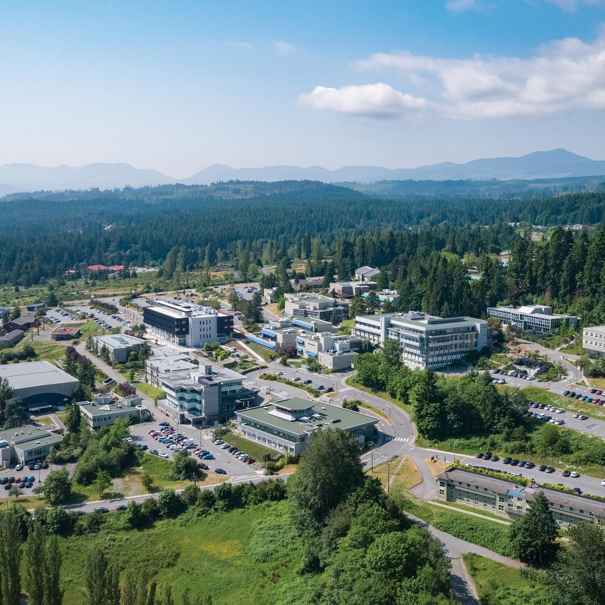 Ariel photograph of the Vancouver Island University campus with several buildings on a hillside on a sunny day