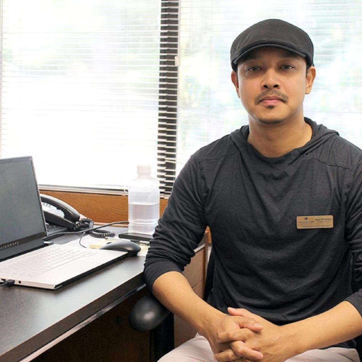 AJ sits at his desk
