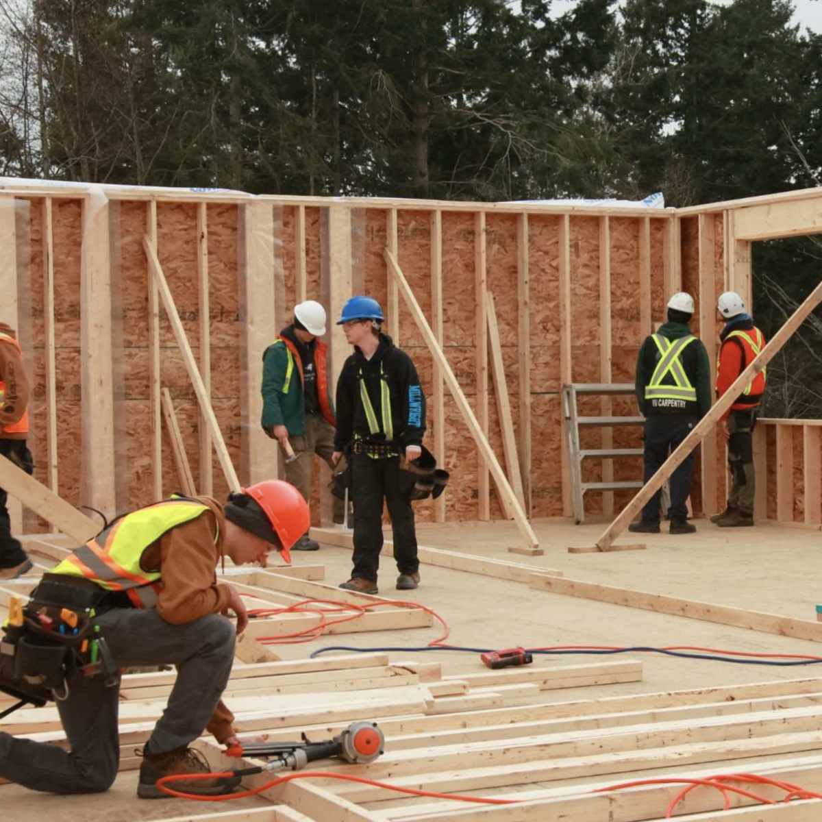 Carpentry students working working on a housing construction site.