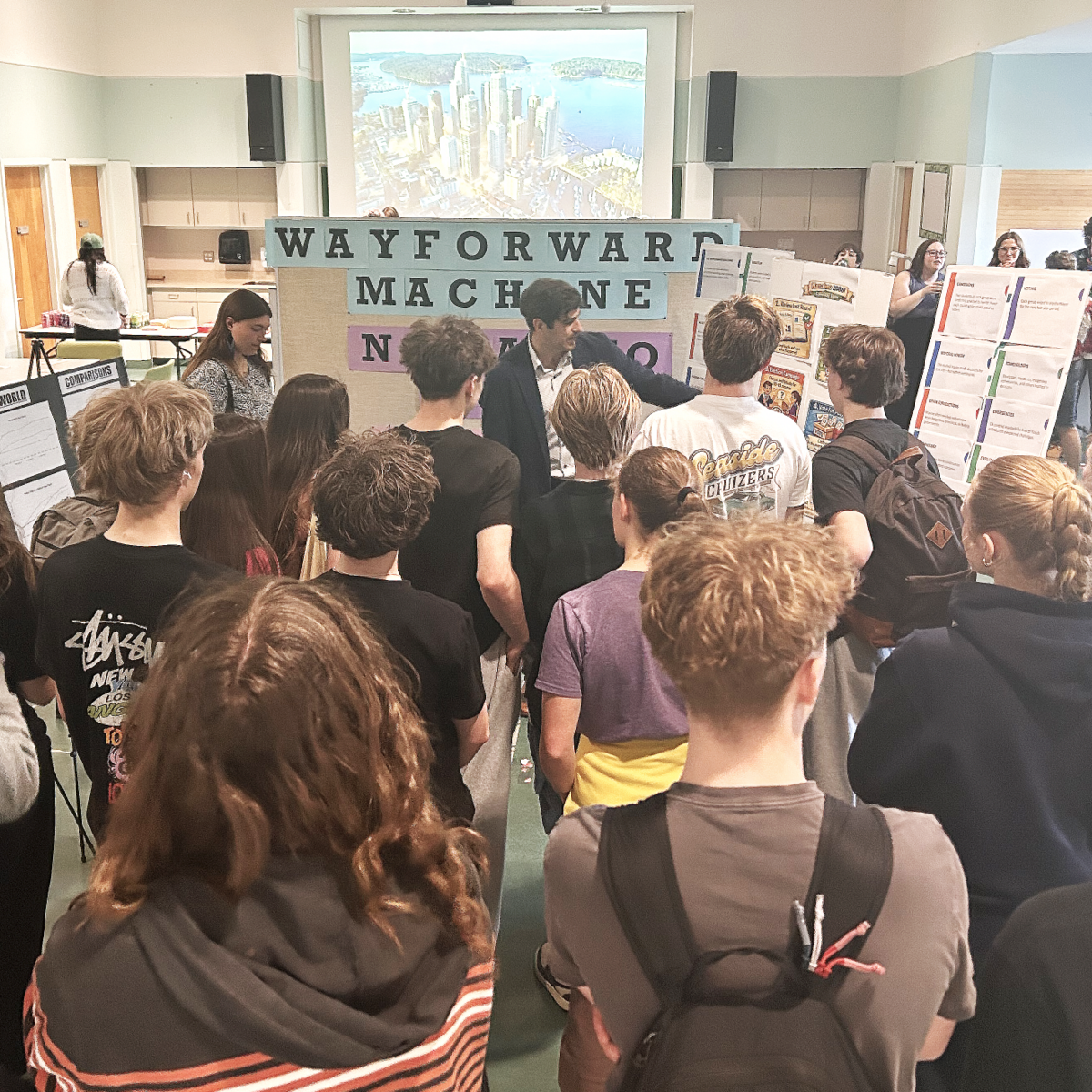 Michael MacKenzie showing a group of students some of the work done for the Futures Fair.