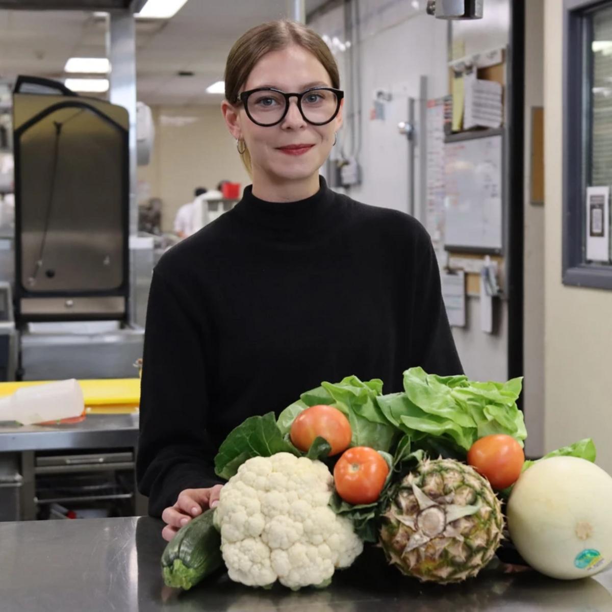 Isabelle with fruits and veggies piled in front of her