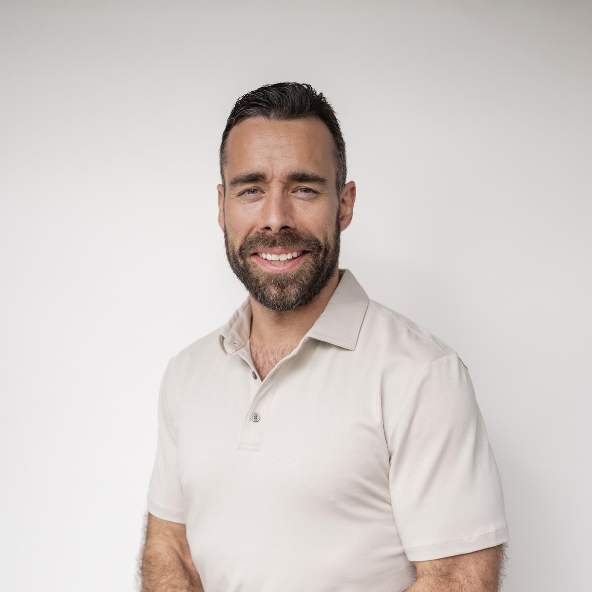 Jake torso and up portrait against a white wall