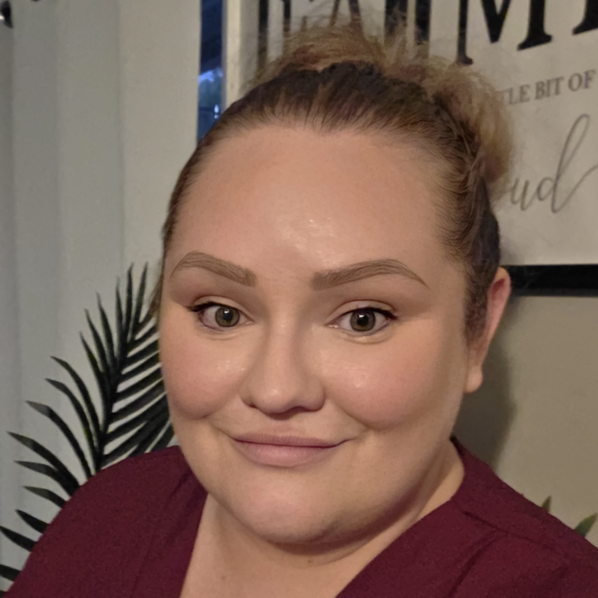 Kylie smiling at the camera wearing a red shirt.