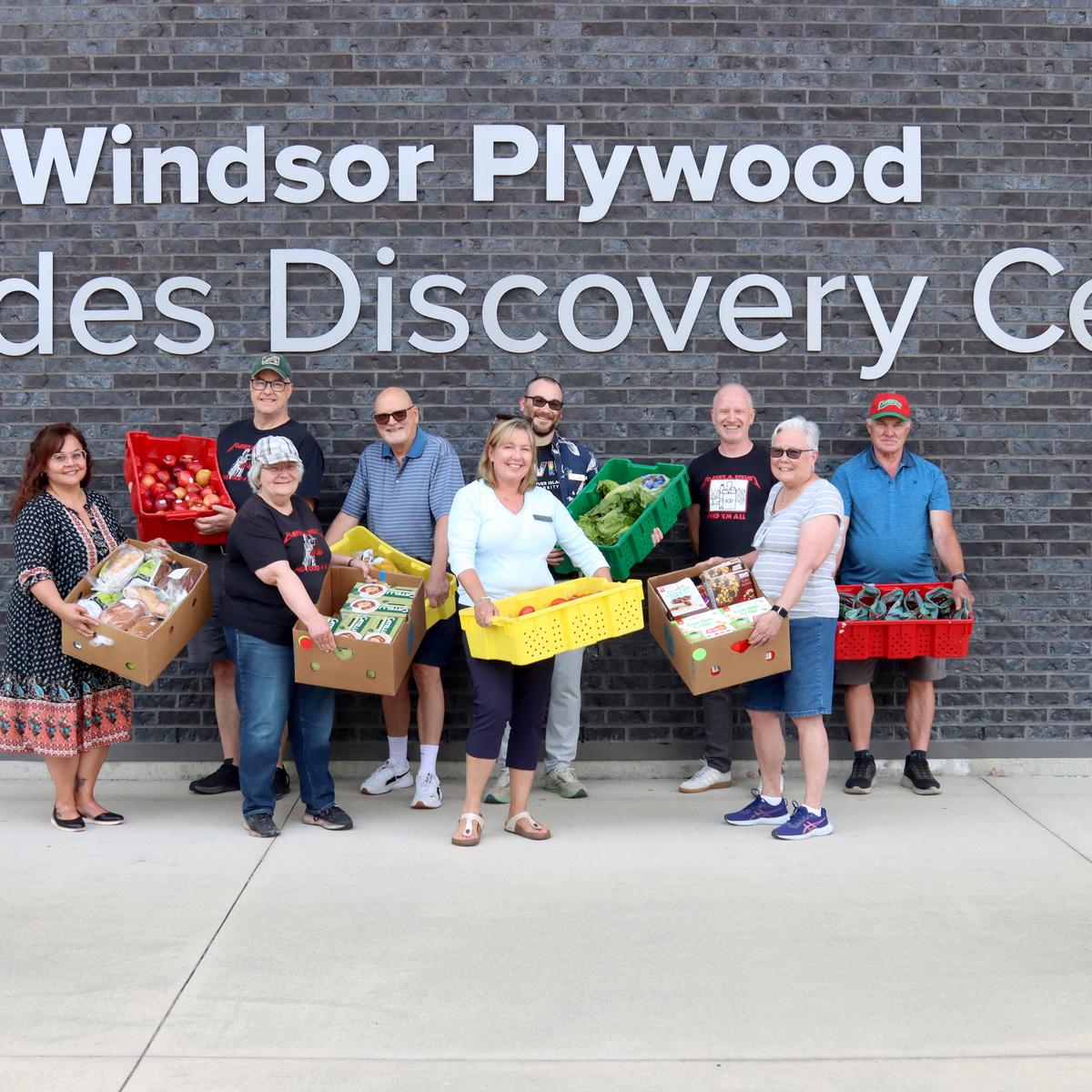 A group of people holding boxes of food outside VIU's Trades Discovery Centre