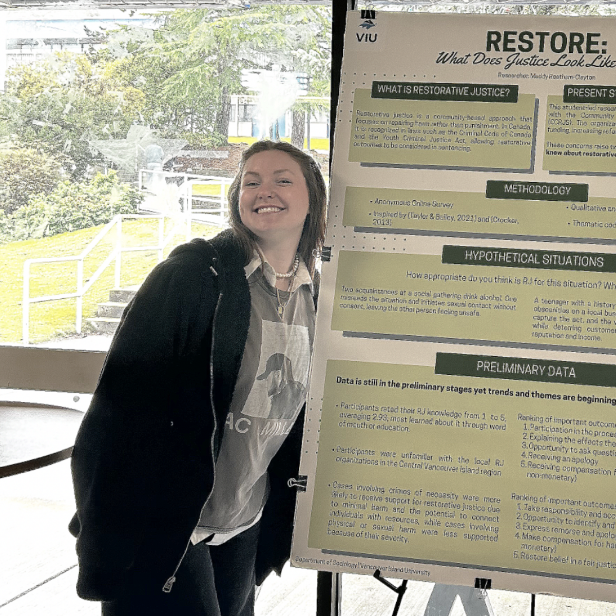 Madelyn in the cafeteria with her research poster