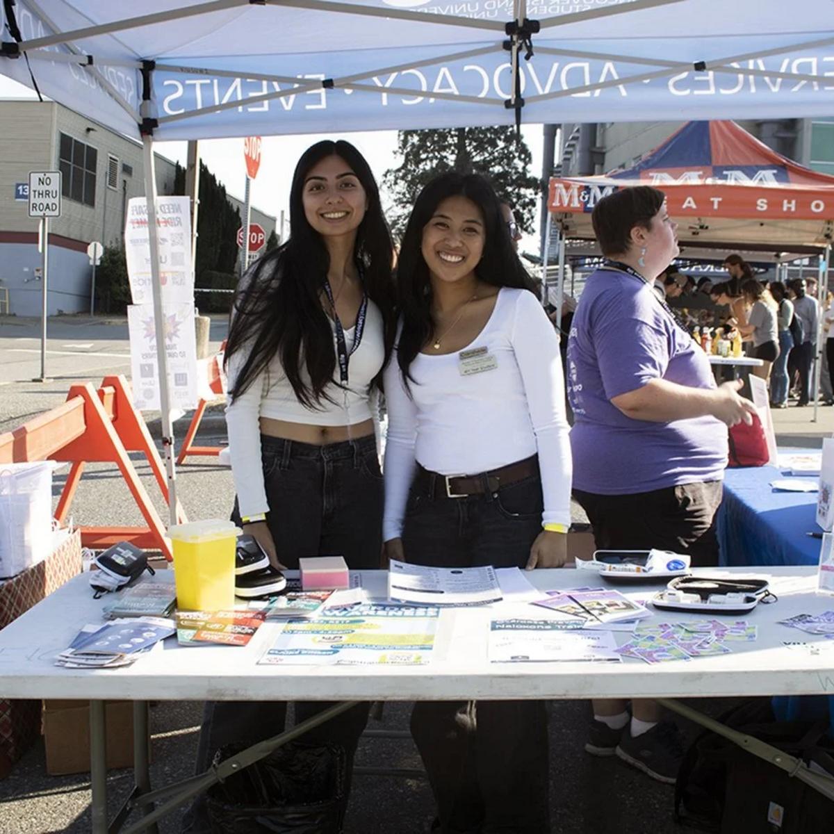 Two students stand at a booth