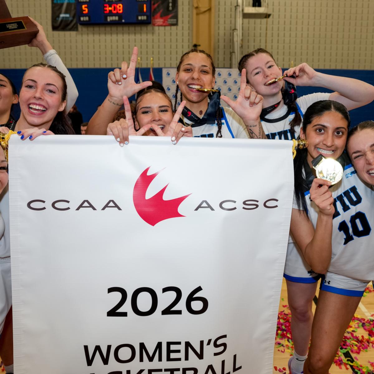 the women's basketball team holds up gold medals