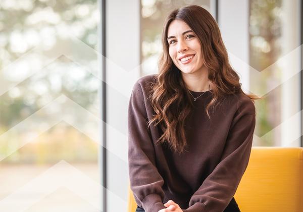 Smiling young woman in front of a window