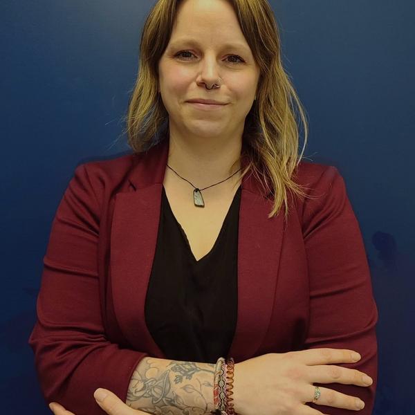 Alison with her arms crossed wearing a cardigan