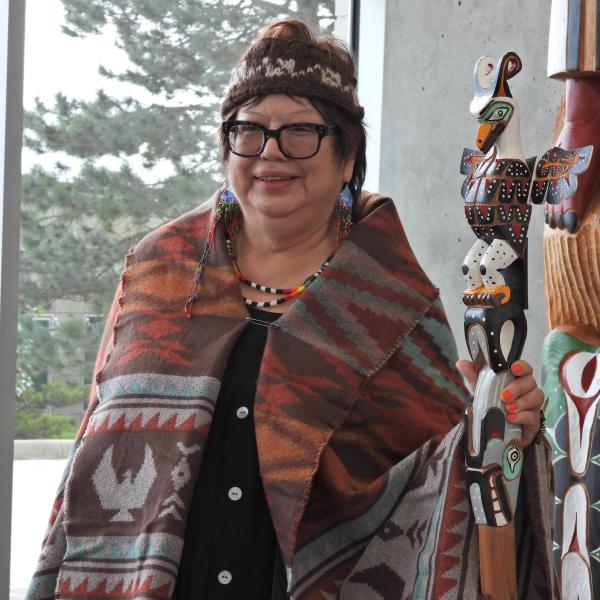 Cloy-e-iss, Dr. Judith Sayers, with the Talking Stick and the totem in the background
