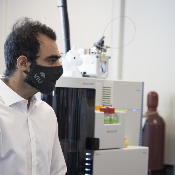 Armin Saatchi stands in front of the Thermo Fisher Scientific Orbitrap Mass Spectrometer System 