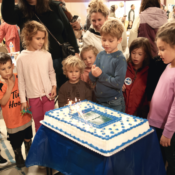 A group of kids admire the birthday cake at VIU tiwšɛmawtxw's  50th birthday celebration