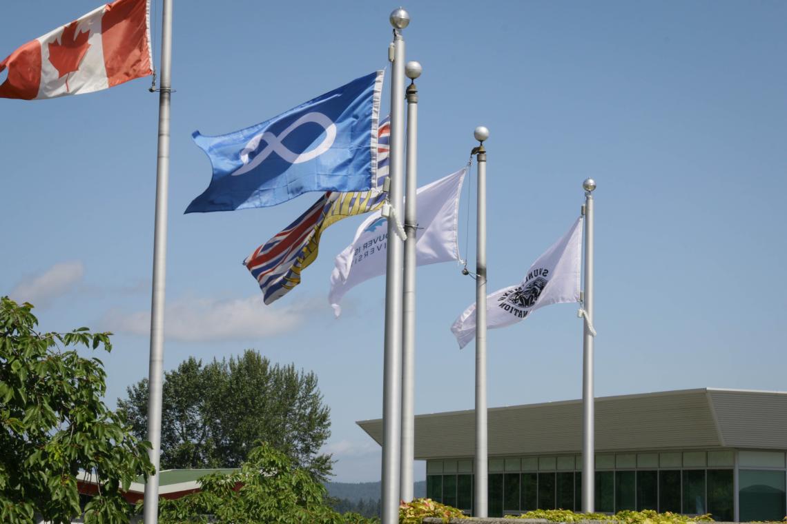 From left to right: the Canadian, Metis, BC, VIU and Snuneymuxw flags flying on campus
