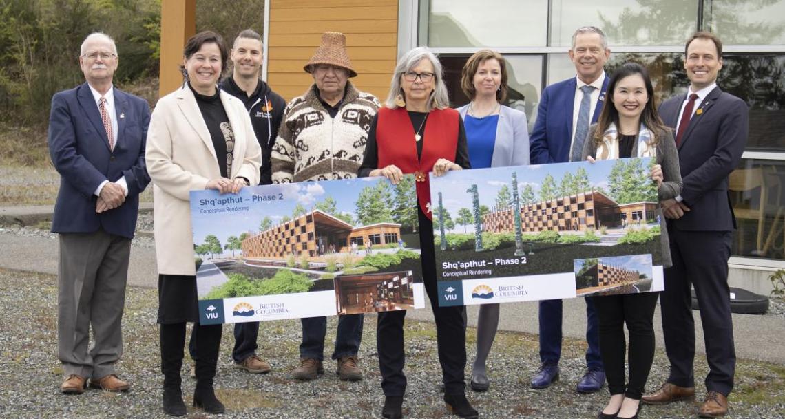 Group holds up conceptual renderings of Phase 2 of Shq'apthut, VIU's Indigenous gathering place