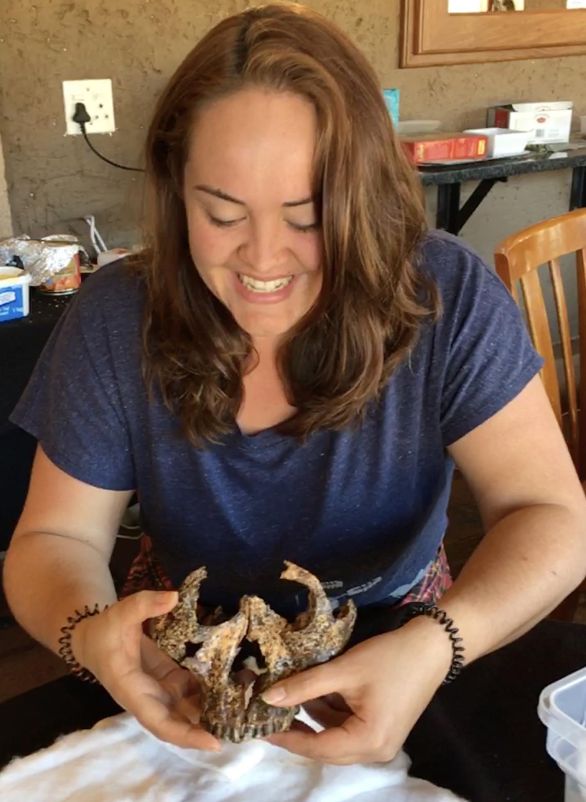 Samantha Good holds the two-million-year-old skull she unearthed.