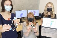 Students and a professor at VIU hold models of molecules in their hands.