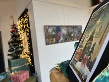 A Christmas Carol poster sits on a stand in front of a Christmas tree.