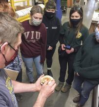 VIU students examine a scallop held by Provan Crump, from Coastal Shellfish Ltd.