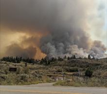A wildfire burns near a road