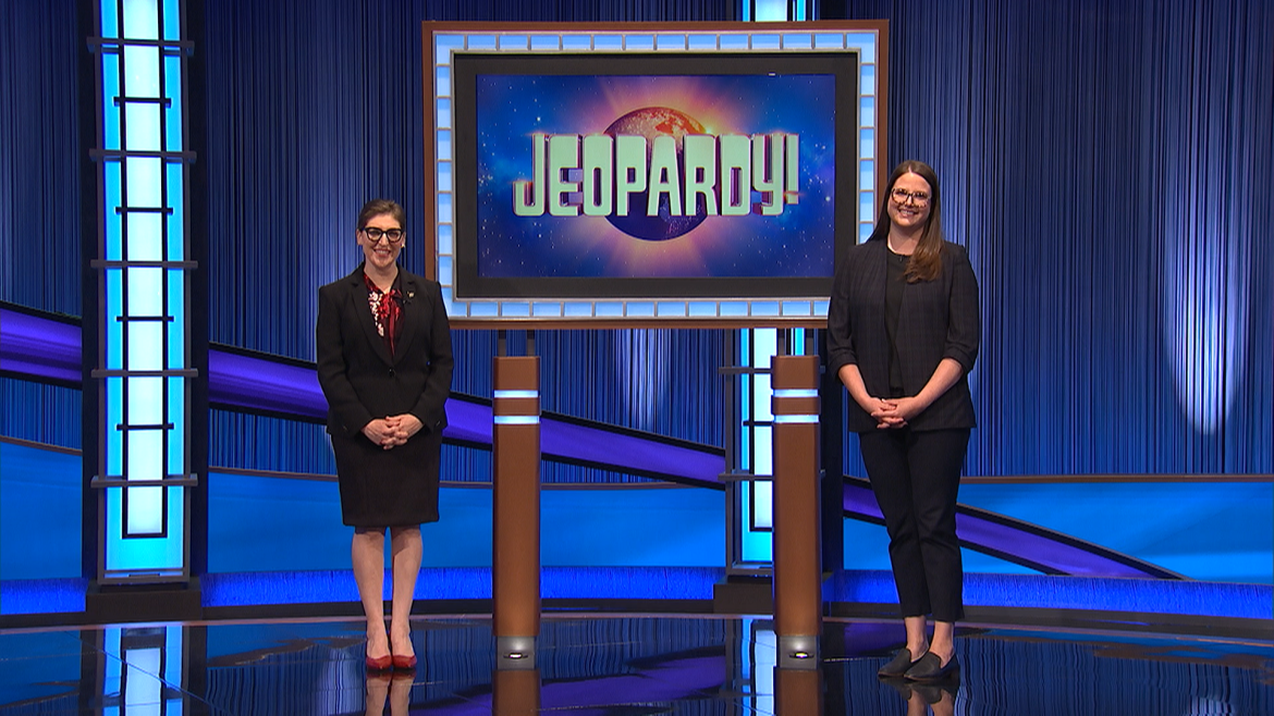 Whitney Wood stands on the Jeopardy! stage with host Mayim Bialik.