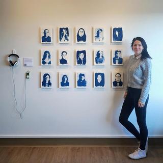 Tarah stands in front of her exhibit