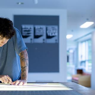 Ronin Carver works at a table in a graphic design classroom at VIU.