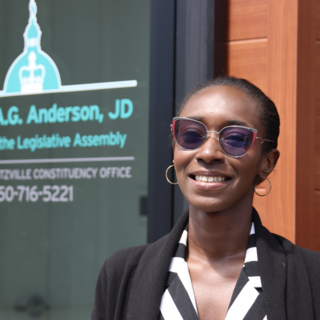 Awula standing outside George Anderson's office and smiling at the camera.
