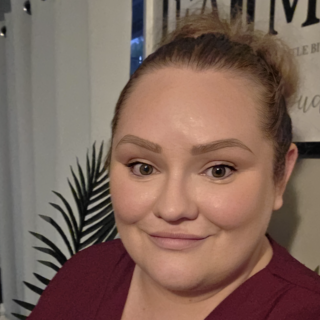 Kylie smiling at the camera wearing a red shirt.