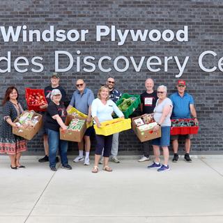 A group of people holding boxes of food outside VIU's Trades Discovery Centre