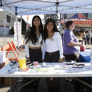Two students stand at a booth