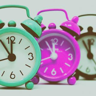 a picture of three small analog alarm clocks
