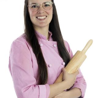 Kate Wilson in a baking uniform holding a rolling pin