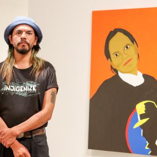 Atticus Mercredi stands near the portrait he painted of his mother.