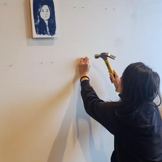 Tarah Dowling hangs her photographs on the wall of the View Gallery.