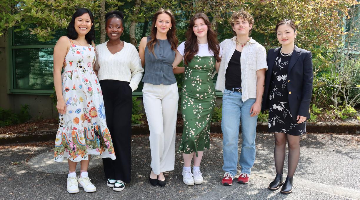 Six Vancouver Island University students standing together in front of a bush