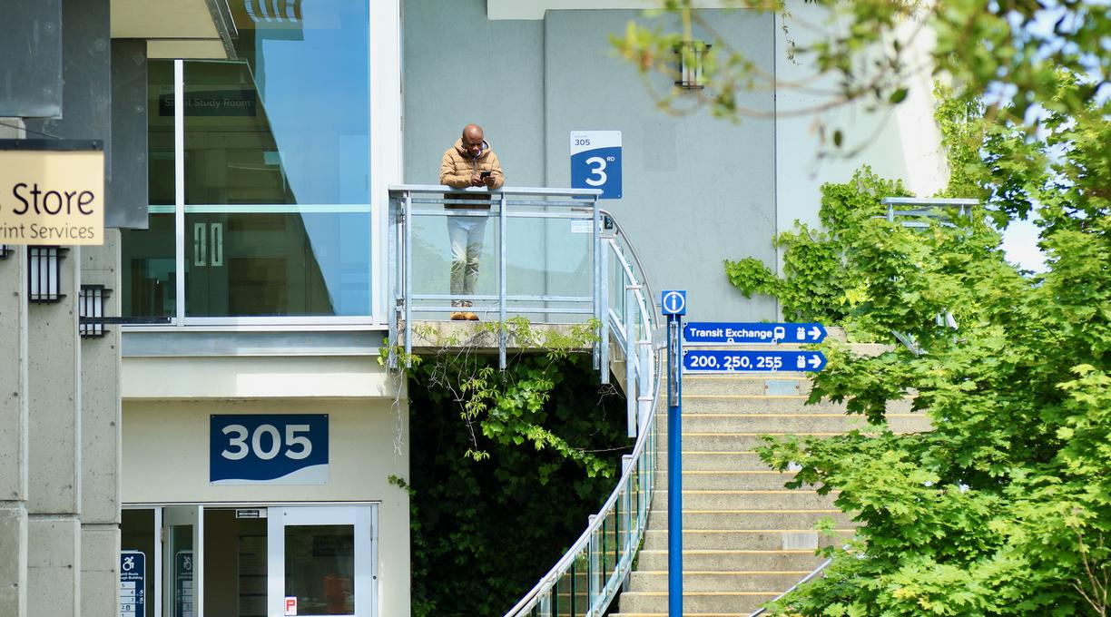 A person stands at the top of the spiral steps outside the VIU Library