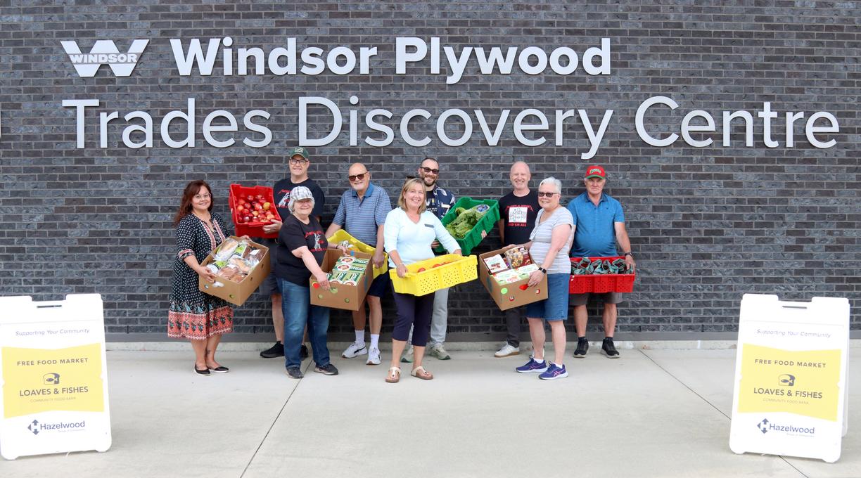A group of people holding boxes of food outside VIU's Trades Discovery Centre