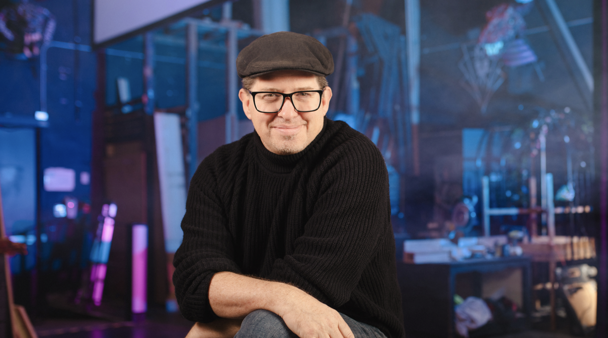 Leon Potter sitting on the stage and smiling at the camera.