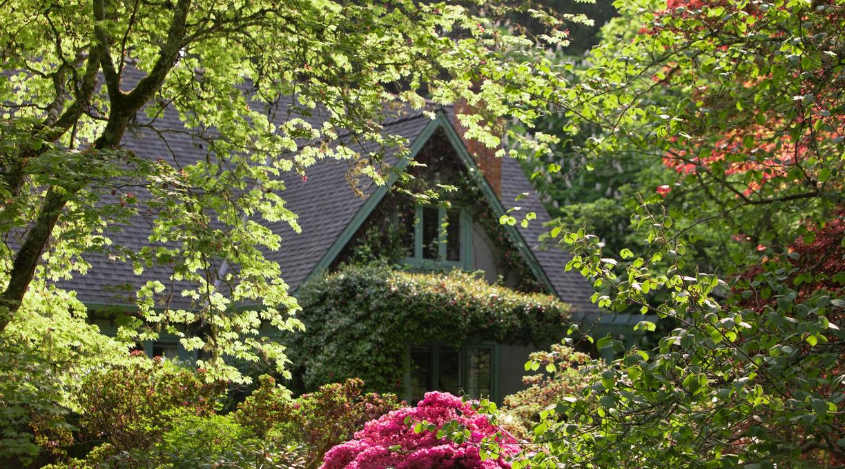Milner House framed by blooming flowers and foliage