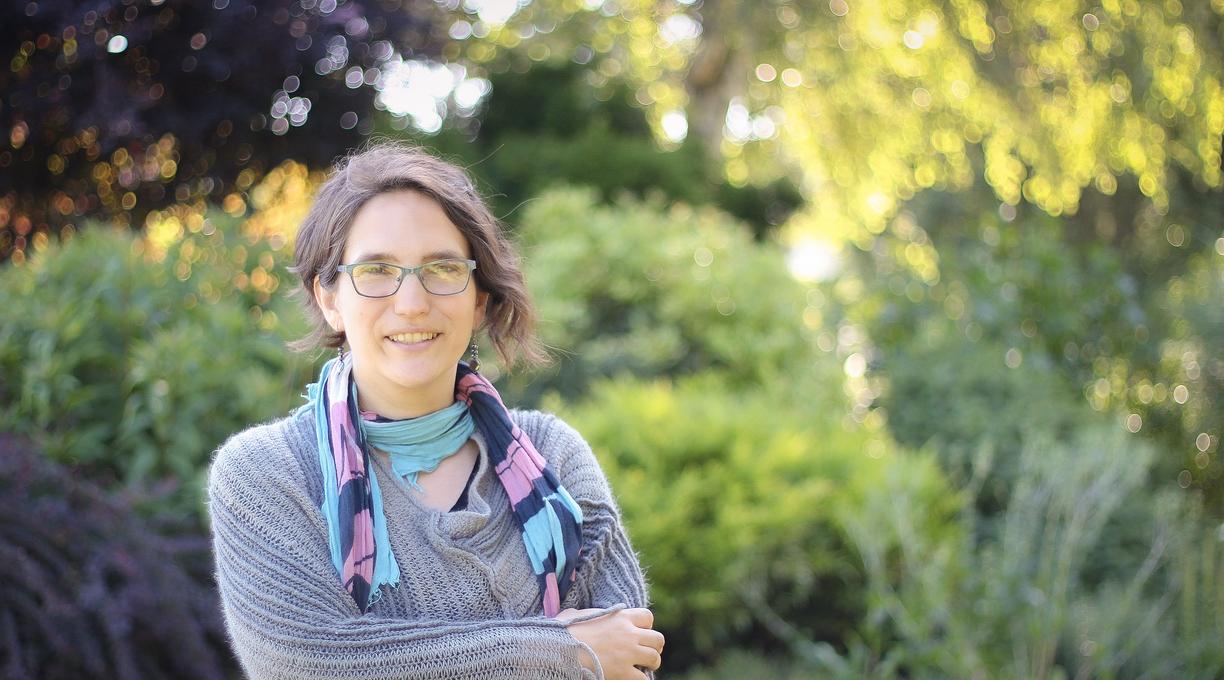 Sharon Karsten standing outside on a sunny day and smiling at the camera.