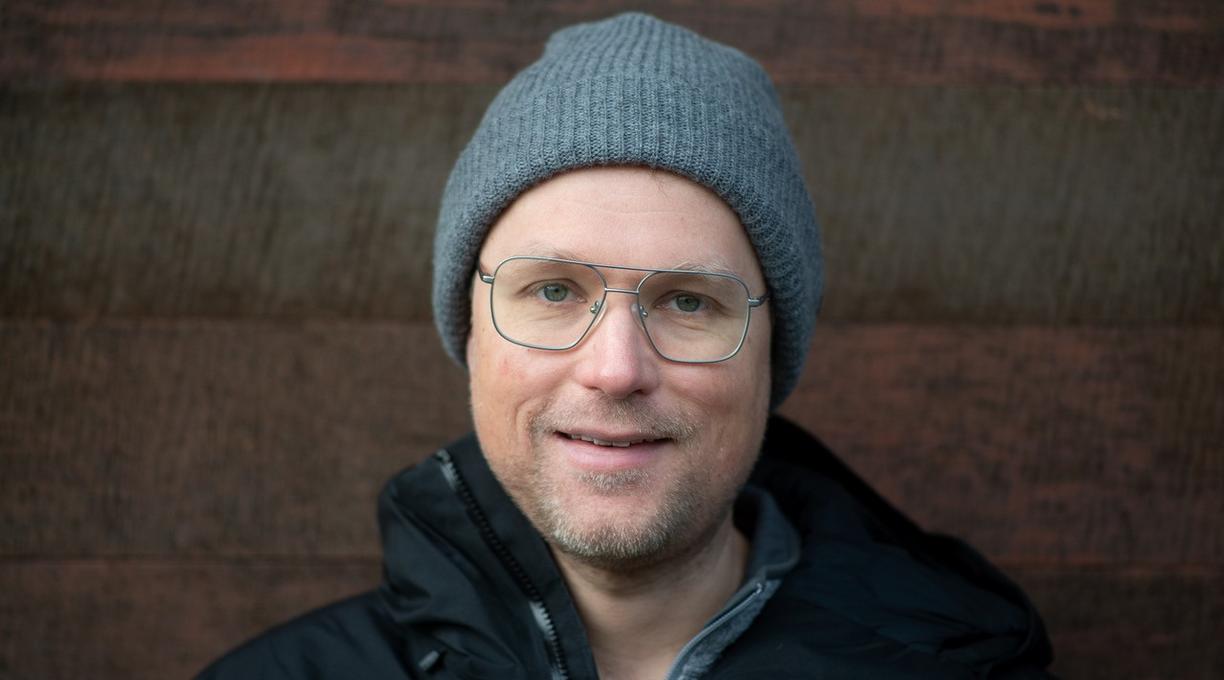 a headshot of trevor wideman, who is wearing a jacket, toque and glasses