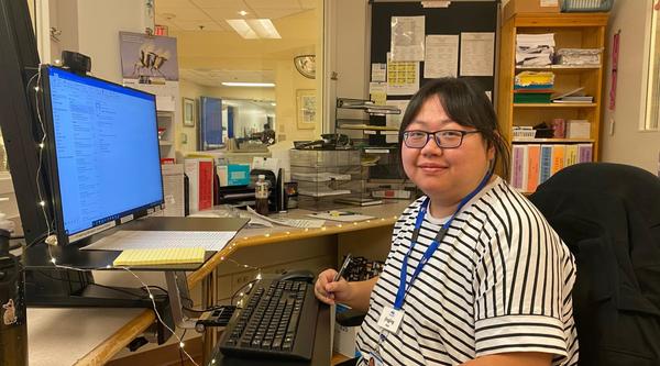 Jingjing sits at a desk in her hospital unit