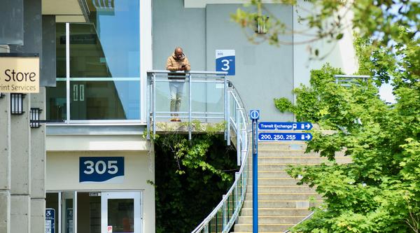 A person stands at the top of the spiral steps outside the VIU Library