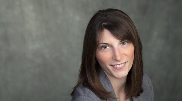 Dr. Lindsay McCunn smiles at the viewer while wearing a grey blazer and shirt.