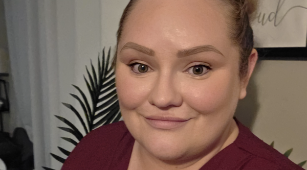 Kylie smiling at the camera wearing a red shirt.