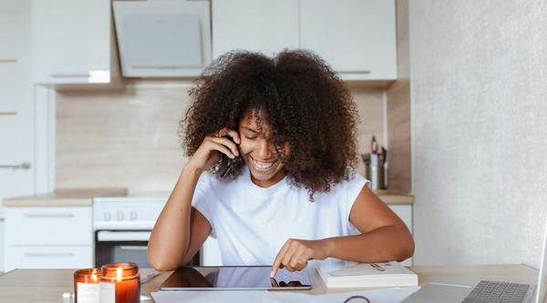 A woman looks at a tablet while sitting at a table