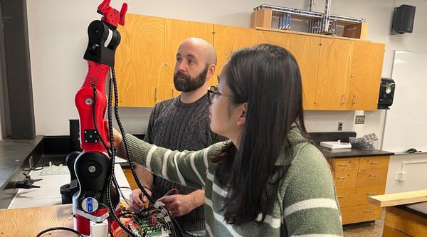 Dr. Xueling (Julie) Luo and Devin Ayotte adjust an 3D robotic arm.