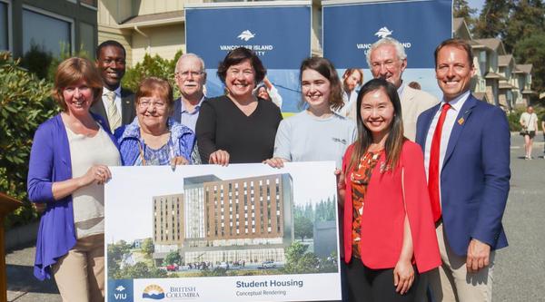 Group holds up a conceptual rendering of the new student housing facility coming to VIU's Nanaimo campus