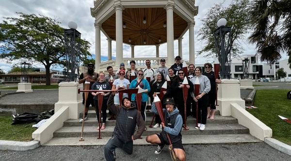 a group holding paddles poses for a photo