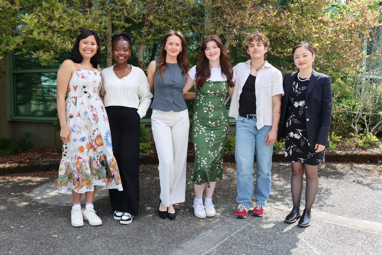 Six Vancouver Island University students standing together in front of a bush
